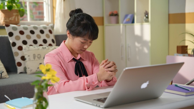 Seorang wanita Kristen berdoa untuk pekerjaannya